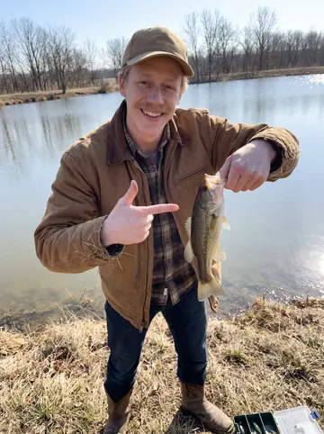 Shane, AI character: a stock pond outside Ada on a clear winter Sunday, dry grass, bare trees and his granddad's old tackle box…