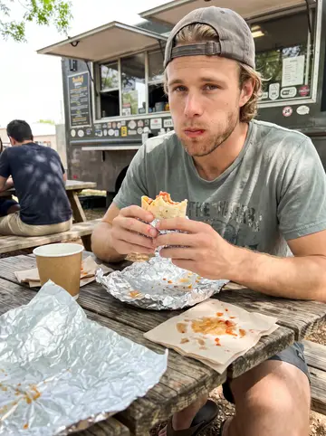 Brody, AI character: picnic table at an East Austin breakfast taco truck