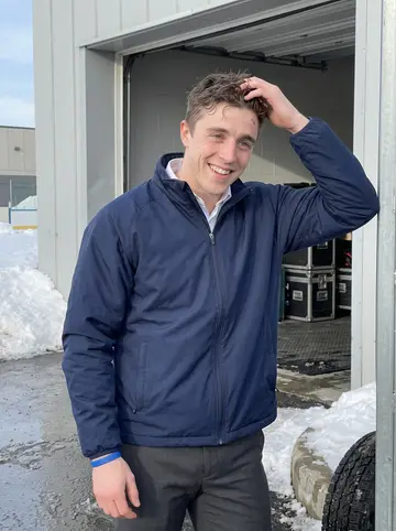 Ronald, AI character: outside the arena loading doors in northern Michigan after morning skate, snow piled along the curb