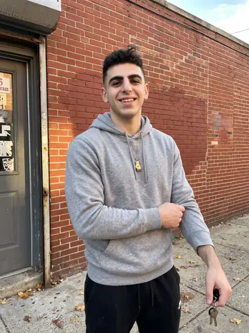 Benjamin, AI character: outside a small boxing gym in Kensington, Philadelphia, red brick wall and gym door behind him