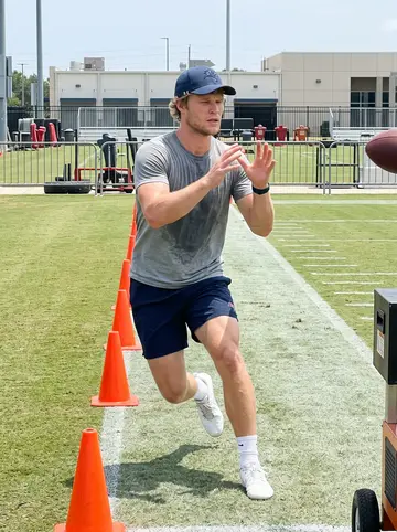 Russell, AI character: team practice facility in Tampa during a hot midday route drill