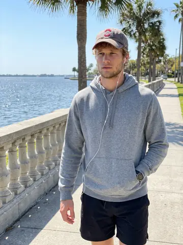 Russell, AI character: Bayshore Boulevard sidewalk during a long playbook walk, palm trees and water behind him