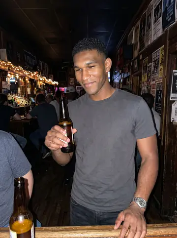 Dre, AI character: a small blues bar near Beale Street in Memphis, at a crowded wooden bar with friends from the depot yard crew