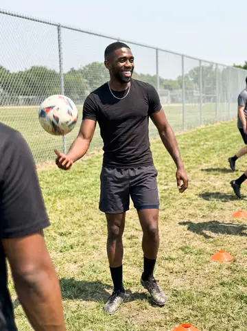 Courtney, AI character: neighborhood soccer field on a Saturday, orange cones scattered near the sideline while his niece's…