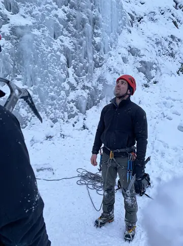 Klaus, AI character: at the foot of a frozen waterfall above Neustift at dusk after ice climbing