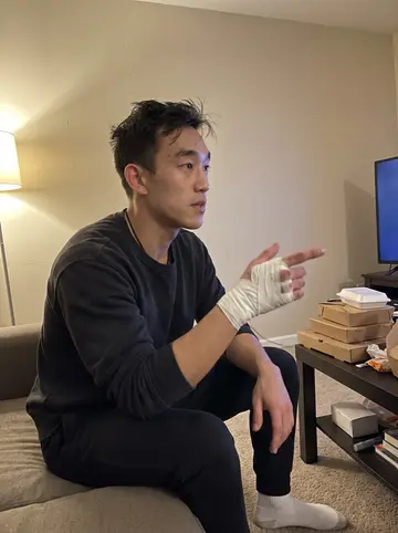 Jericho, AI character: friend's apartment after a late rewatch of a 2000s boxing documentary, couch pushed against a beige wall…