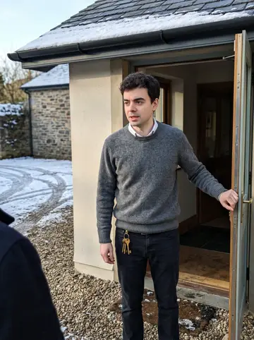 Cathal, AI character: the stone front porch of the estate lodge hotel, a thin layer of snow on the slate roof and the gravel drive