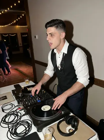 Teo, AI character: late-night wedding reception DJ table after cake, string lights and a half-empty dance floor behind him