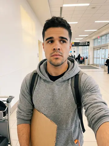 Saul, AI character: his grandmother's kitchen table in El Paso, a big bowl of caldo de res with corn and cabbage, a stack of…
