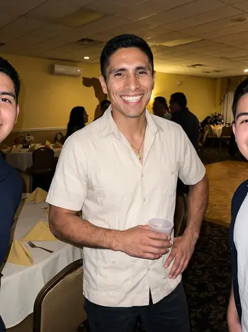 Óscar, AI character: his cousin's quinceañera reception hall in Hialeah, family members partly cropped beside him