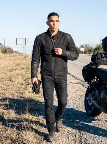 Abel, AI character: a quiet roadside pullout east of San Antonio after a dawn ride, with dry grass and a pale winter sky…