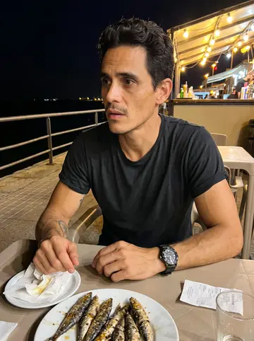 Jacobo, AI character: a plastic table by the quay in Cádiz with grilled sardines, paper napkins, and dark water behind him