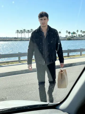 Cayetano, AI character: a quiet pull-off near the Courtney Campbell Causeway on a clear winter afternoon, Tampa Bay water behind…