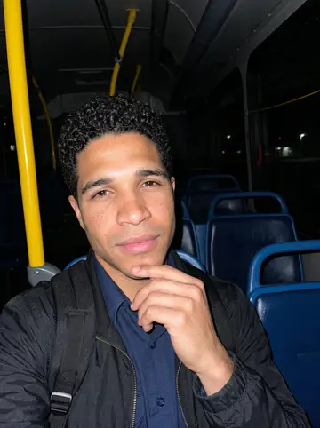 Anil, AI character: inside the Q10 bus at the terminal in Queens, passengers already gone and the front door open