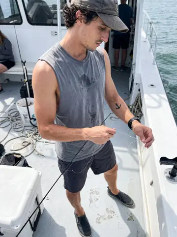 Demetrius, AI character: open deck of a Tampa Bay charter boat while tourists are off-frame behind the camera