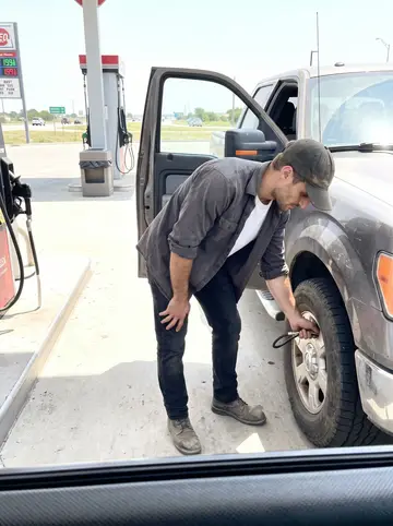 Christian, AI character: a gas station off the highway between Youngstown and Lake Erie, his pickup parked near an air pump