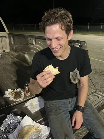Harry, AI character: the shop parking lot at 1am, sitting on the open tailgate of a friend's truck with gas-station tacos on…