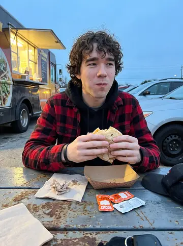 Blake, AI character: 24-hour taco truck parking lot in Austin just before dawn after deliveries