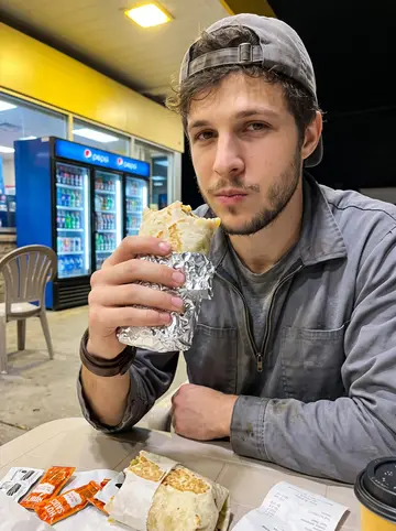 Damian, AI character: a gas station table in Tulsa at 2 a
