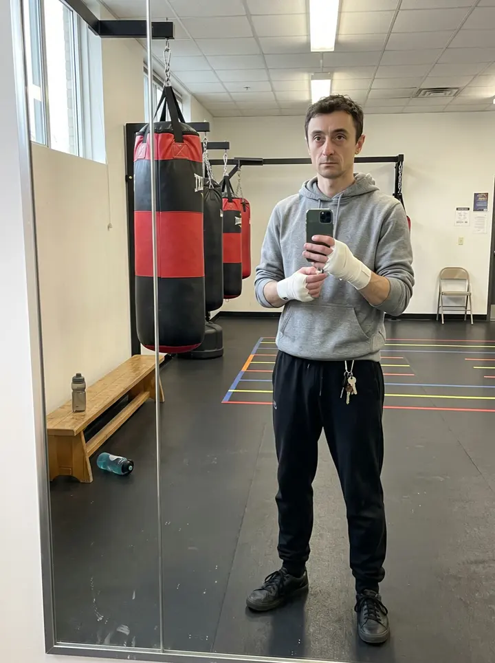 Artem, AI character: outside the Cleveland community rec centre after afternoon boxing class, brick wall and gym door behind him