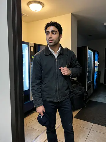 Tariq, AI character: a quiet Fort Worth crew corridor just after midnight, vending machines and a crew-room door behind him