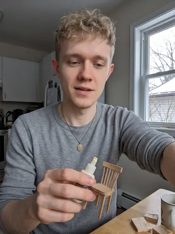 Stanislav, AI character: small kitchen table in his apartment above a Polish deli in Jefferson Park, bare tree branches and a bit…