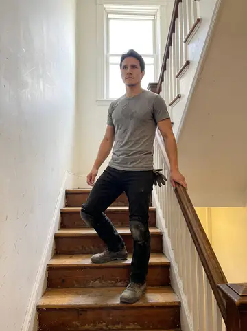 Erwan, AI character: the narrow stairwell of an old Back Bay walk-up during a furniture move