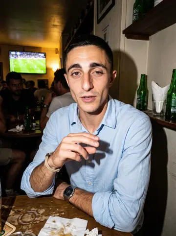 Cédric, AI character: a small Marseille football bar with old men behind him watching the match, green bottles and paper napkins…