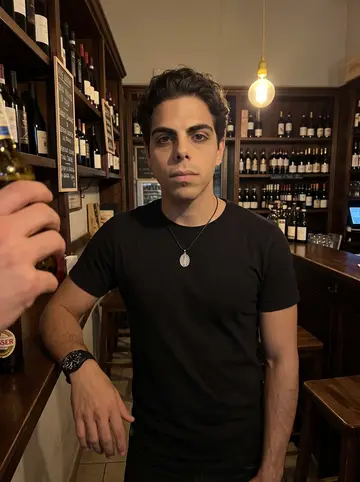 Vito, AI character: a small wine bar in Taranto's old town, a dark wooden counter and a tiled wall behind him