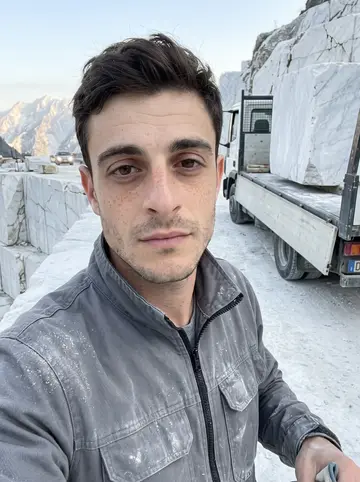 Enzo, AI character: the ledge of a white marble quarry above Carrara at about 5:45 a