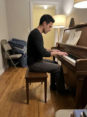 Eliseo, AI character: the back room of his apartment, an abandoned upright piano against a wall, a folding chair, moving…