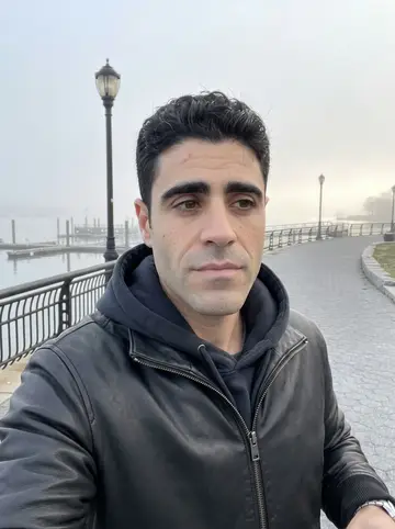 Rodolfo, AI character: India Point Park harbor path before work, fog low over the water and the first light just starting behind…