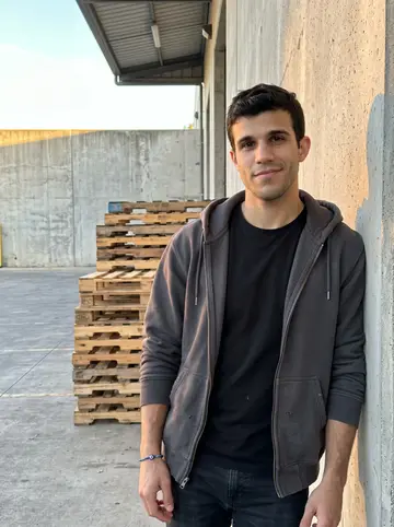 Damianos, AI character: outside the night dock in Tampa after shift change, leaning against a concrete wall by the loading bay…