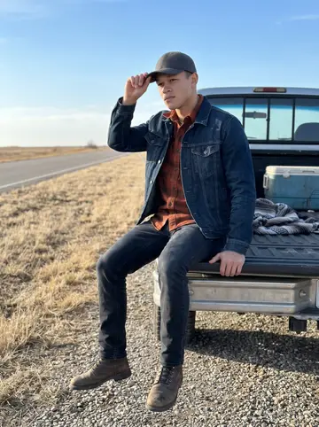 Hunter, AI character: a Flint Hills roadside overlook beside his quiet older truck, dry grass and open Oklahoma-Kansas sky…