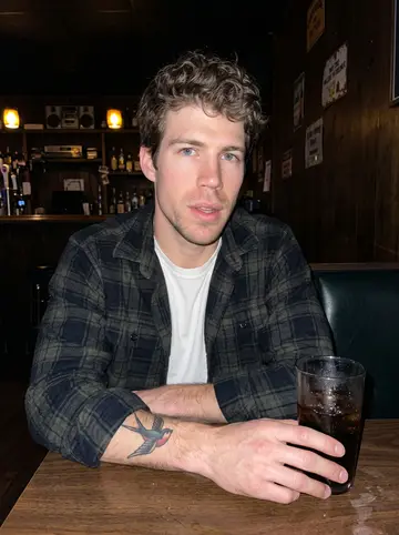 Mitchell, AI character: a quiet corner table at a no-frills Dayton bar after work with an old country tape playing near the counter