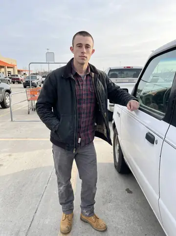 Carter, AI character: parking lot outside a building supply store on a clear cold morning, borrowed older white pickup with…