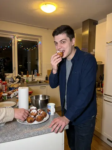 Merijn, AI character: a family kitchen on New Year's Eve, a plate of oliebollen on the counter and holiday lights reflected in…