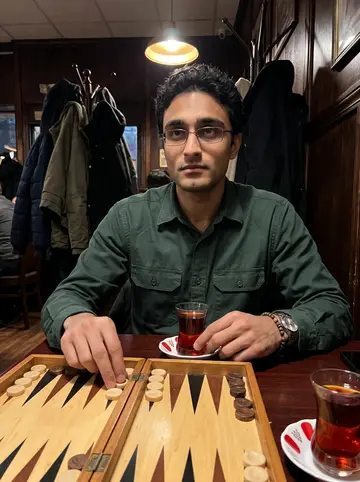 Hakan, AI character: a Turkish tea house in Paterson, sitting at a small table with a tavla board and tulip tea glasses