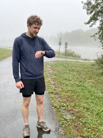 Eoin, AI character: the Neponset River trail in Dorchester just after dawn, damp path and low fog over the water
