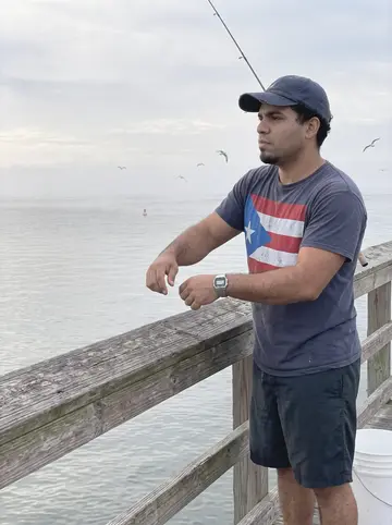 Marcos, AI character: at the end of the Fort De Soto pier at sunrise, grey Gulf water and a low fog