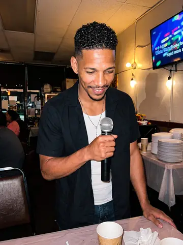 Marlon, AI character: a small Filipino restaurant in Vallejo on Saturday karaoke night, plastic tablecloths and a karaoke screen…