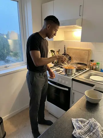 Dayo, AI character: his small apartment kitchen after rain, phone propped low on the counter while he cooks from his mother's…
