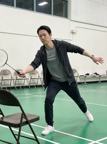 Vincent, AI character: Thursday night badminton league inside a Monterey Park community gym, green court floor and folding chairs…