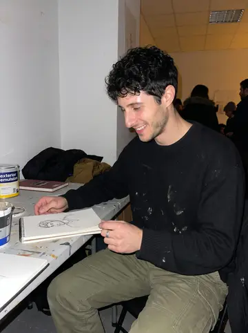Yassine, AI character: a crowded community art night in a back room near Noailles, sketchbooks and cheap exterior emulsion on the…