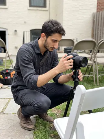 Tobia, AI character: the back garden of a Brooklyn townhouse during a daytime wedding setup, before guests arrive