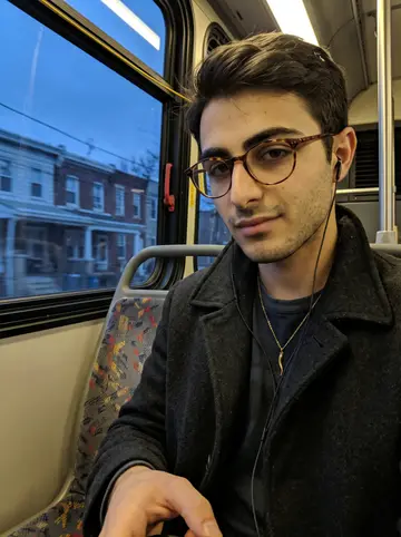Bernardo, AI character: a 47 bus seat by the window during blue hour, South Philly rowhouses sliding by outside