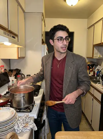 Bernardo, AI character: a crowded family kitchen above the corner bakery during Sunday gravy night, sauce pot and mismatched…