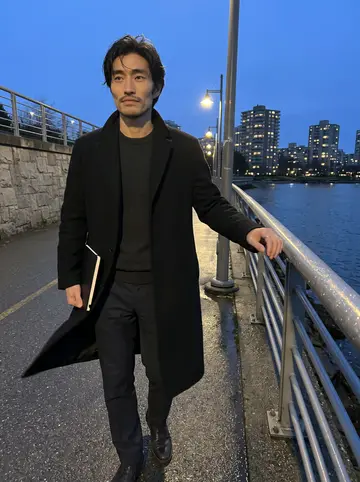 Kazuki, AI character: the Vancouver seawall after work, wet pavement, dark water and apartment lights behind him