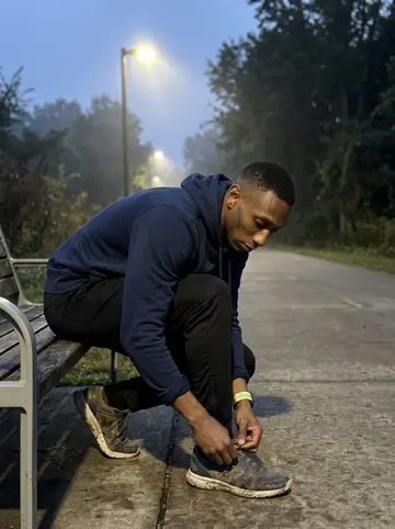 Tevin, AI character: a quiet section of the Atlanta BeltLine before sunrise, damp pavement and low fog around the path lights