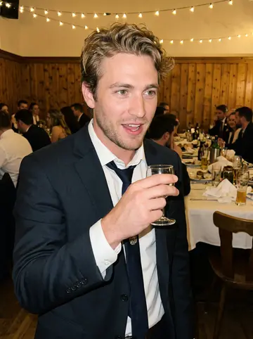 Steffen, AI character: his sister's wedding reception in a Bavarian Gasthaus, warm string lights and crowded tables behind him